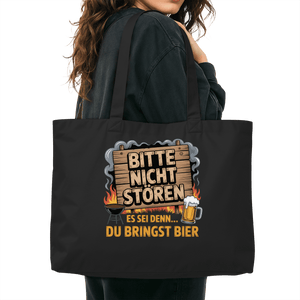 Person holding a stylish organic shopping bag with 'Bitte nicht stören – es sei denn du bringst Bier' message, BBQ-themed design.