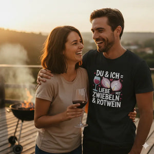 Paar lacht auf Grill-Terrasse, Mann trägt schwarzes Shirt 'Liebe mit Zwiebeln & Rotwein', Meatware Vibe