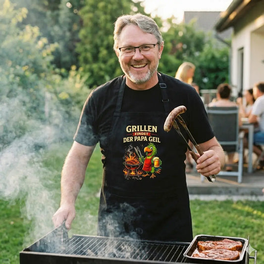 Vater lacht in der schwarzen Meatware Schürze mit buntem Grill-Papagei am brennenden Grill