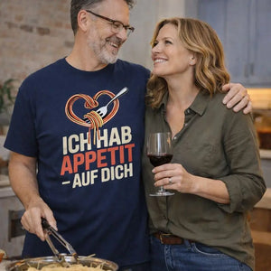 Paar steht gemeinsam in der Küche und trägt Meatware Premium T-Shirt mit Spruch ›Ich hab Appetit auf Dich‹ – humorvolles Liebesdesign zum Thema Liebe geht durch den Magen