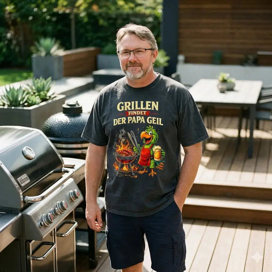 Lässiger Vater im schwarzen Meatware Oversized-Shirt aus schwerer Baumwolle mit buntem Papagei-Motiv am Grill.
