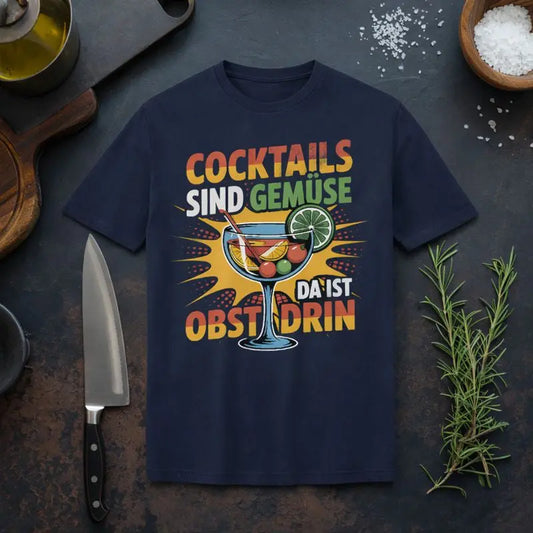 Meatware Bio-Baumwoll T-Shirt „Cocktails sind Gemüse – Da ist Obst drin“ mit buntem Cocktailglas-Illustrationsmotiv auf dunkelblauem Shirt, rustikales Küchen-Mockup