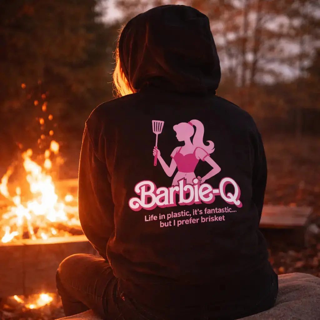Barbie-Q BBQ Hoodie mit pinkem Grill-Girl Motiv und Spruch „Life in plastic it's fantastic but I prefer brisket“, Rückendruck Hoodie im Lagerfeuer Mockup, BBQ und Grill Lifestyle Design