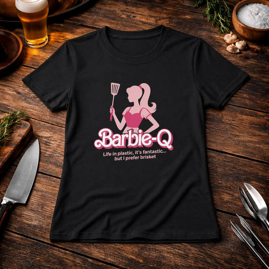 Premium Organic Women T-Shirt with Barbie-Q brisket BBQ design on black shirt, styled on rustic wooden table with beer, grill tools and herbs – Meatware Shirts & more mit Geschmack