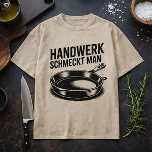 Beiges Oversized T-Shirt von Meatware mit Pfannen-Motiv und Schriftzug ›Handwerk schmeckt man‹ – ehrliches Küchen- und Handwerks-Statement.