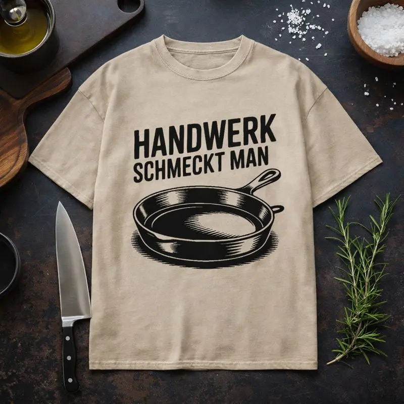 Beiges Oversized T-Shirt von Meatware mit Pfannen-Motiv und Schriftzug ›Handwerk schmeckt man‹ – ehrliches Küchen- und Handwerks-Statement.