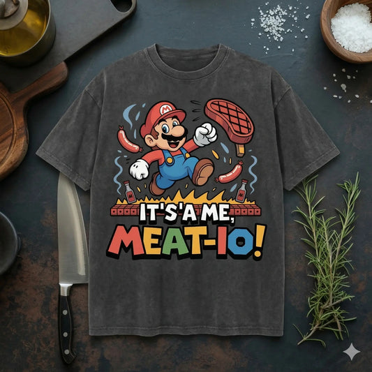 Meatware BBQ Gamer T-Shirt mit humorvollem Grill-Design "It's a me Meat-io" auf beigem Premium Shirt in rustikalem Küchenmockup mit Messer, Rosmarin und Salz