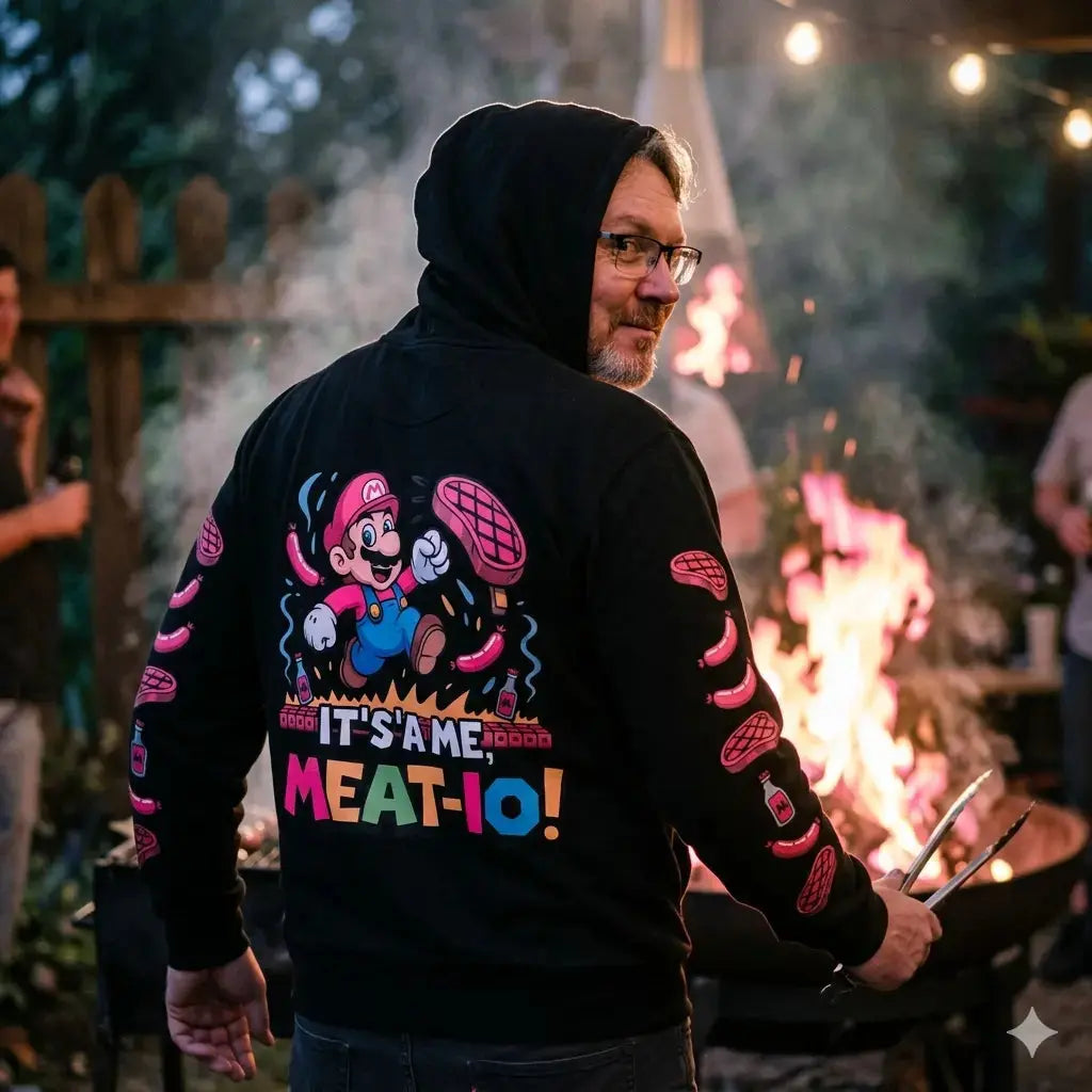 Authentischer Schnappschuss eines Mannes am Grill, der ein Mario-BBQ-Kapuzenpullover trägt und schelmisch grinst.