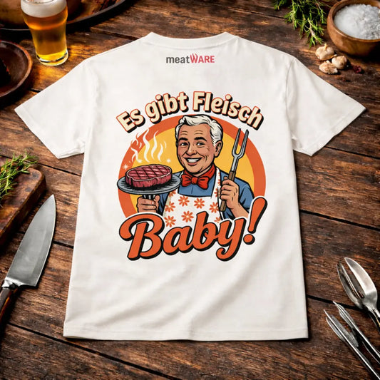 Weißes BBQ T-Shirt mit „Es gibt Fleisch Baby“ Grillmotiv im rustikalen Meatware Mockup auf Holztisch mit Bier, Knoblauch und Grillbesteck sowie Meatware Logo im Nackenbereich