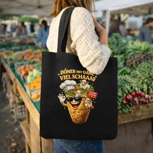 Schwarzer Meatware Jutebeutel mit lustigem Döner Motiv „Döner mit ganz viel Schaaaf“ – humorvolle Baumwolltasche mit Cartoon Döner und Schaf Design auf Wochenmarkt getragen