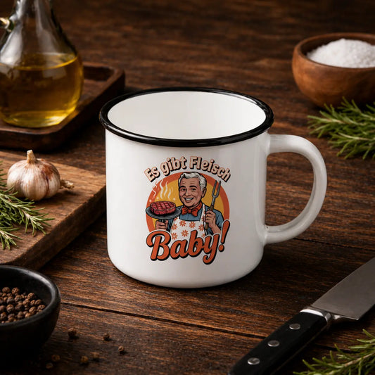 Weiße Emaille-Tasse mit schwarzem Rand und „Es gibt Fleisch Baby“ Grillmotiv im rustikalen BBQ Mockup auf Holztisch mit Knoblauch, Kräutern, Öl und Messer, robuste Optik und hochwertiger Druck.