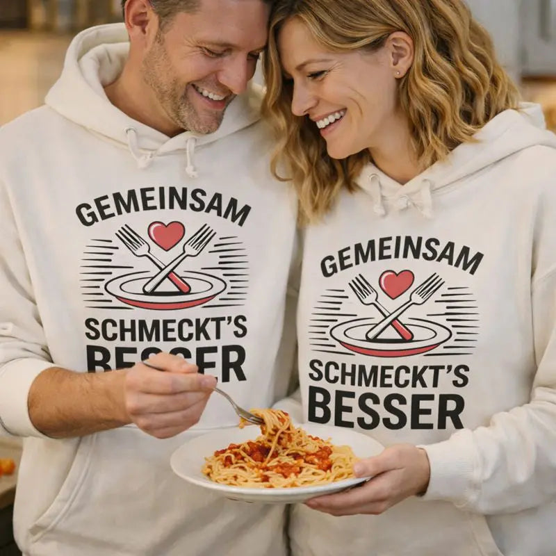Paar trägt Meatware Oversized Hoodies „Gemeinsam schmeckt’s besser“ beim gemeinsamen Kochen in der Küche – Liebe geht durch den Magen