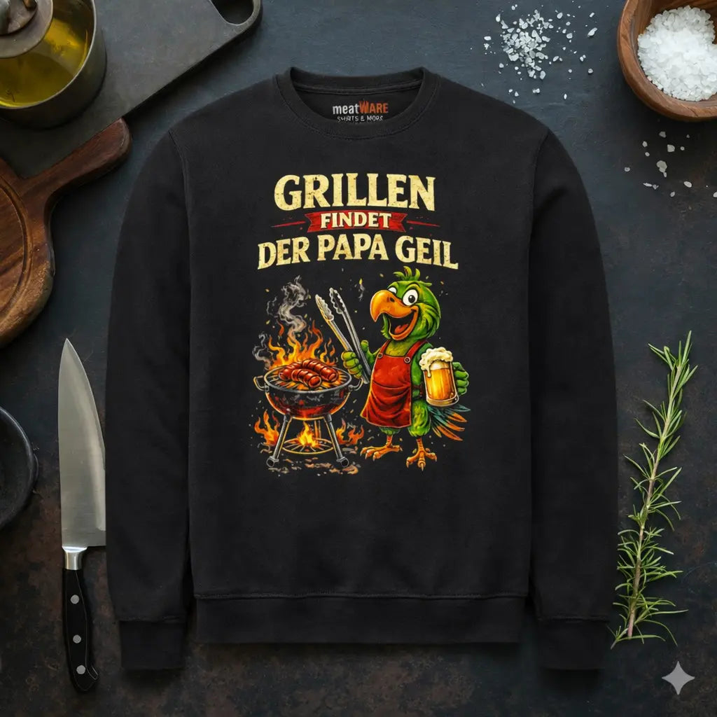 Schwarzes Meatware Premium Sweatshirt mit lustigem BBQ Papagei Design „Grillen findet der Papa geil“, Grillmotiv mit Bier und Würstchen im rustikalen Küchen Mockup – Shirts & more mit Geschmack