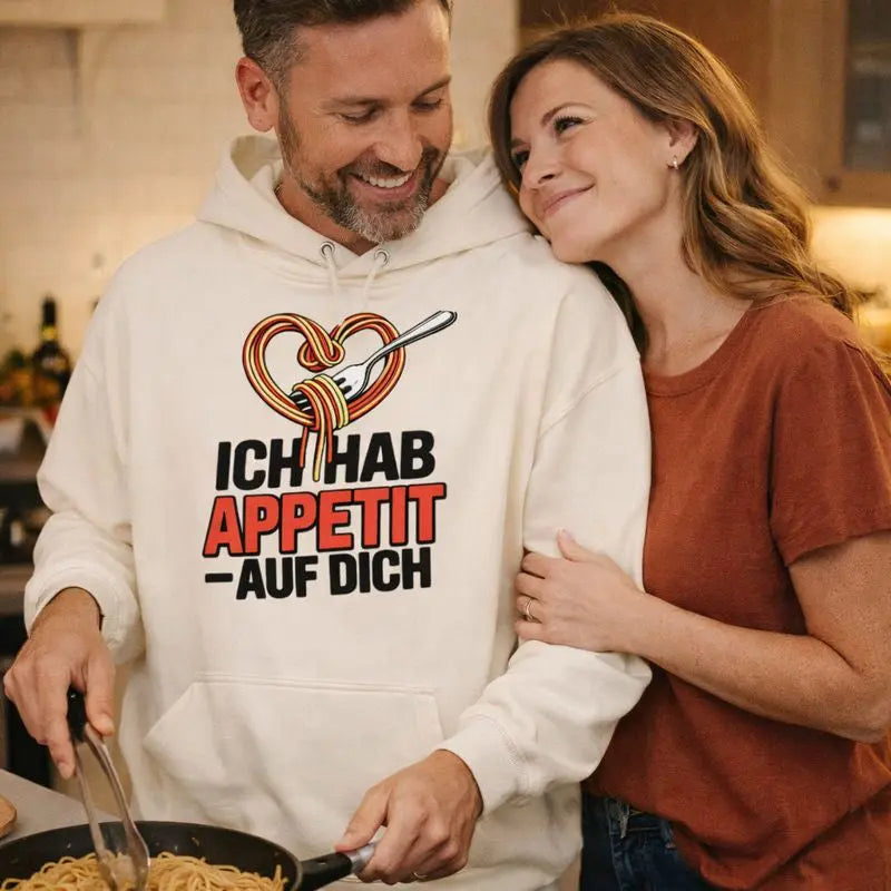 Paar in gemütlicher Küche trägt hellen Meatware Oversized Hoodie mit Spaghetti-Herz-Motiv und Schriftzug „Ich hab Appetit auf Dich“ – humorvolles Liebesdesign, Liebe geht durch den Magen