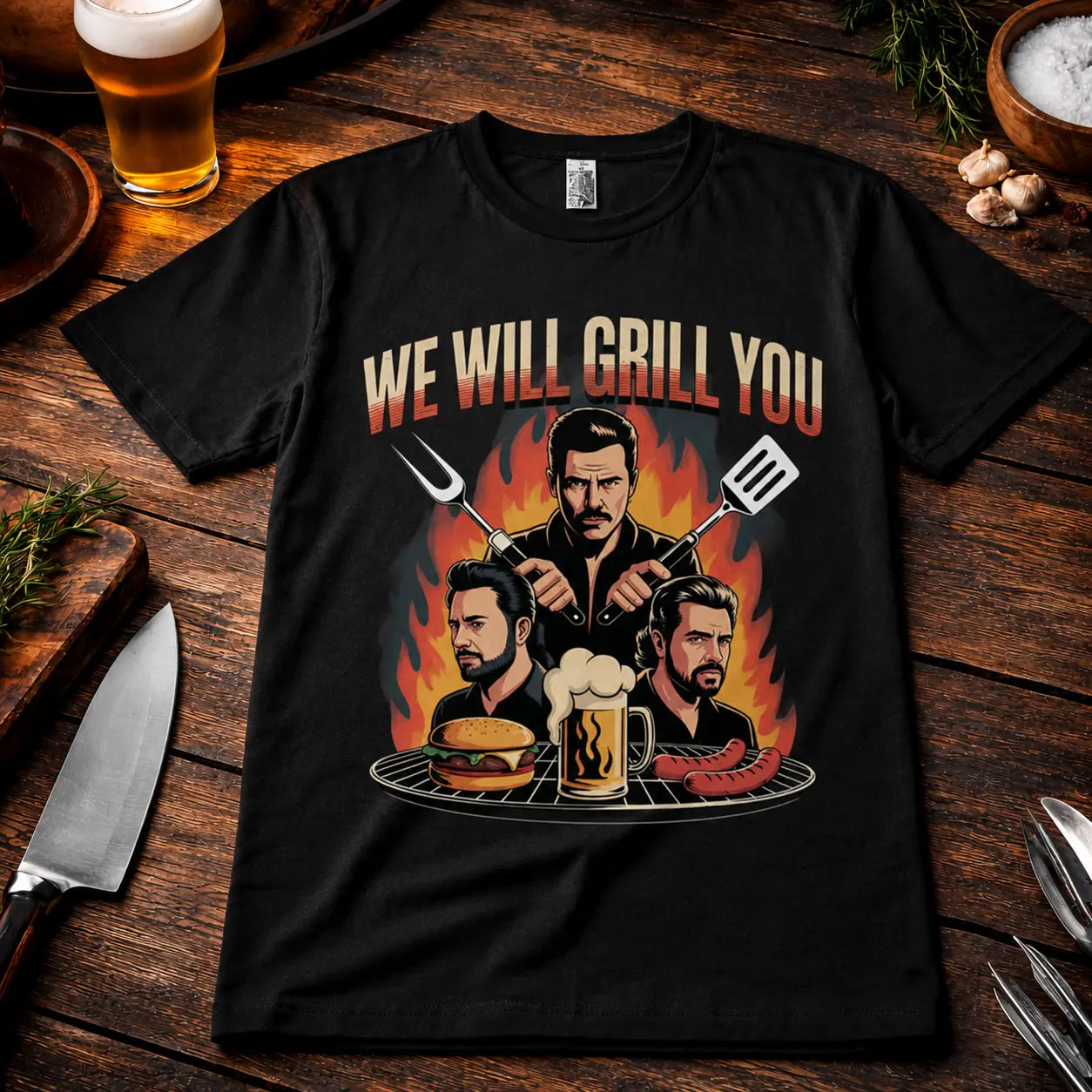Meatware We Will Grill You T-Shirt mit humorvollem Rock-inspiriertem BBQ Design, Grillmeister, Burger, Bier und Würstchen auf schwarzem Shirt im rustikalen Grill-Mockup mit Bier, Kräutern und Grillbesteck.